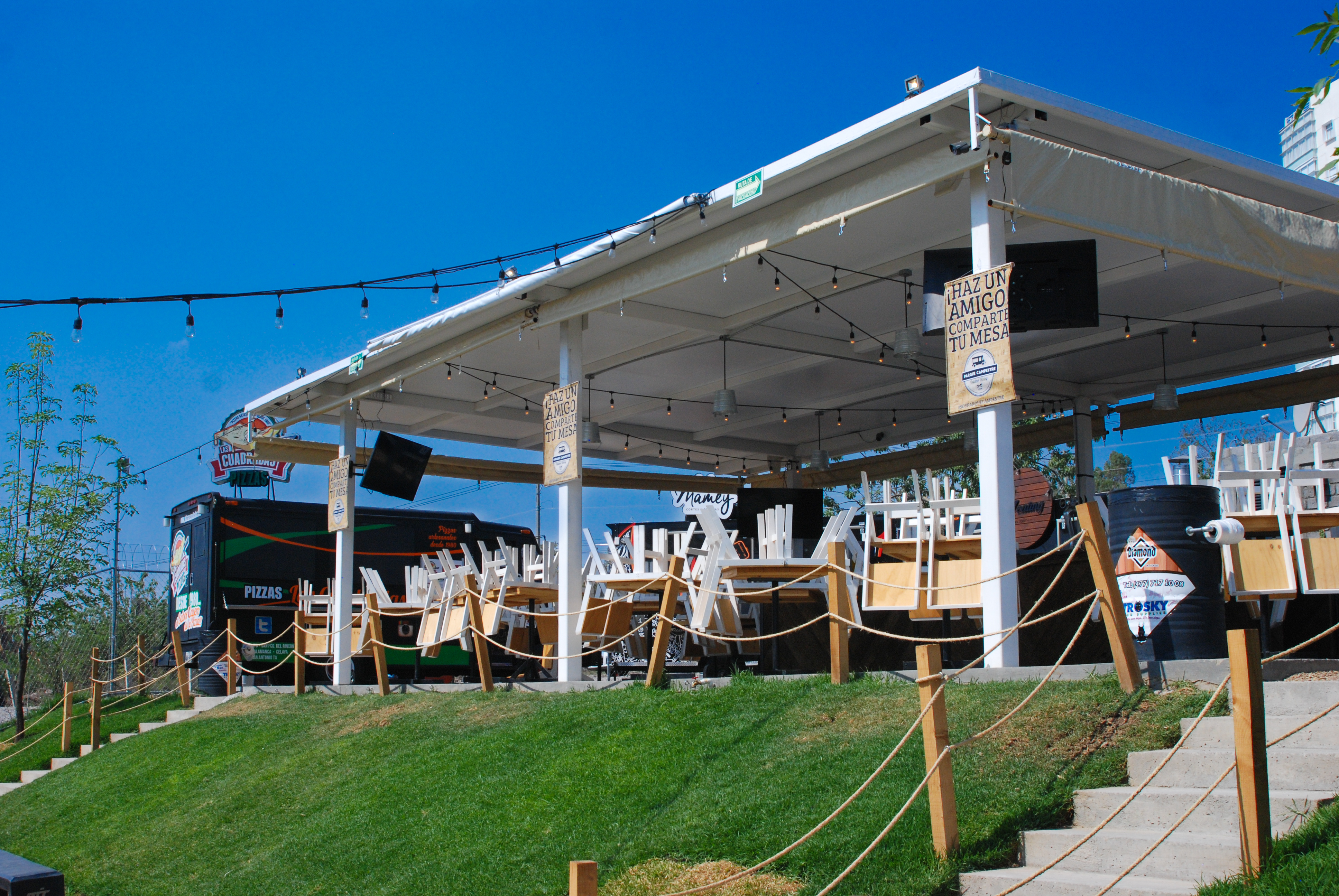 Espacio exterior con estructura de toldos y área de convivencia, proyecto urbano Fer Et Ciment en León